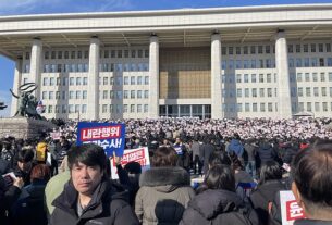People, gathered in front of the National Assembly Building, protest following the declaration of martial law in Seoul, South Korea on December 04